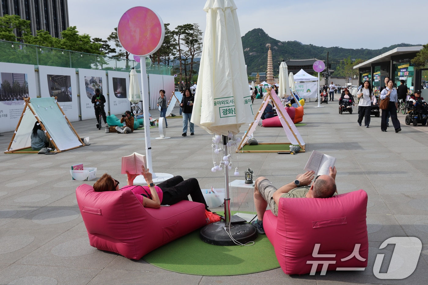 서울야외도서관 운영이 시작된 23일 오후 서울 종로구 광화문광장에 마련된 '광화문 책마당'에서 외국인 관광객들이 책을 읽고 있다. 2026.4.23 ⓒ 뉴스1 안은나 기자
