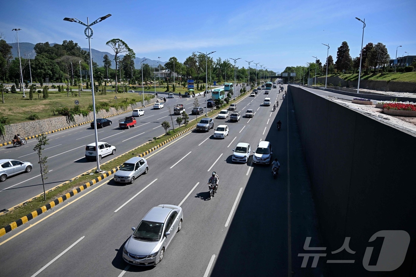 26일 파키스탄 이슬라마바드 레드존 지역이 보안 조치 완화로 재개방된 뒤, 통근차들이 미·이란 평화회담 1차가 열렸던 세레나 호텔 인근 도로를 달리고 있다.2026.04.26.ⓒ AFP=뉴스1