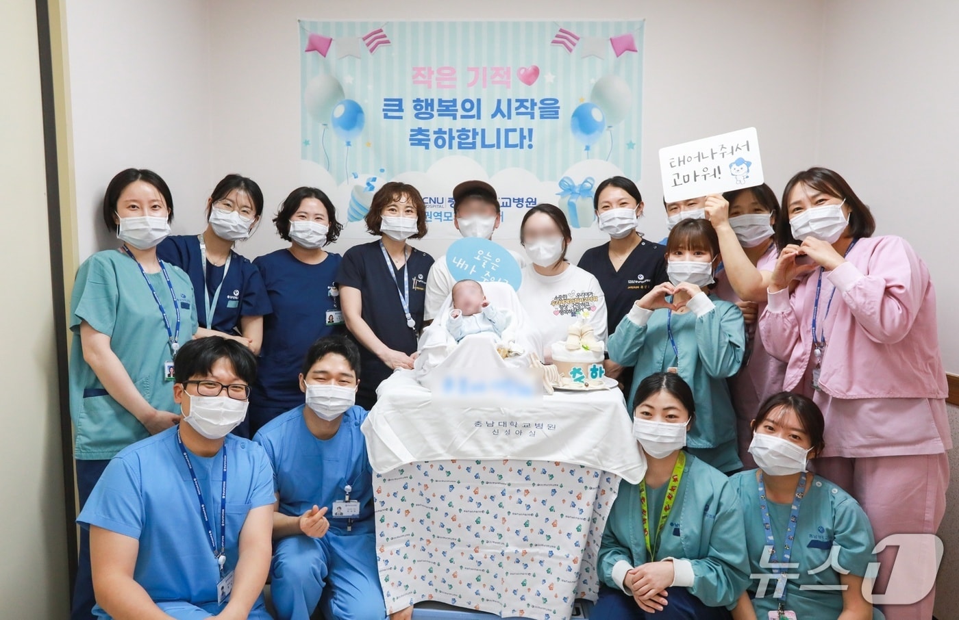 충남대학교병원 신생아중환자실에서 무사히 치료받고 퇴원한 이른둥이 환아와 가족들이 의료진과 기념사진을 촬영하고 있다.(충남대병원 제공) /뉴스1