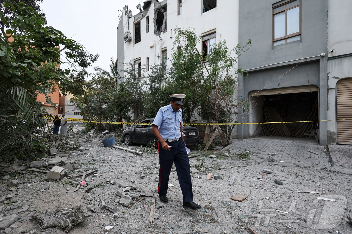 지난 4일(현지시간) 바레인 시트라에서 한 경찰관이 이란 무인기(드론) 파편이 떨어진 현장을 살피고 있다. 2026.04.04. ⓒ 로이터=뉴스1