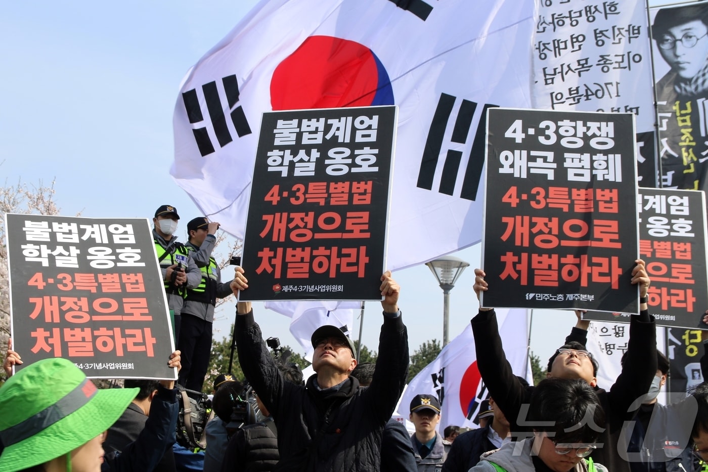 78주년 제주4·3희생자 추념식이 열리고 있는 3일 오전 제주시 봉개동 제주4·3평화공원 인근에서 민주노총 관계자들이 '불법 계엄 학살 옹호 4·3특별법 개정으로 처벌하라'는 팻말을 들고 있다. 이날 이곳에서는 추념식과 동시에 일부 극우단체 50여 명이 집회 신고를 했다.2026.4.3 ⓒ 뉴스1 홍수영 기자