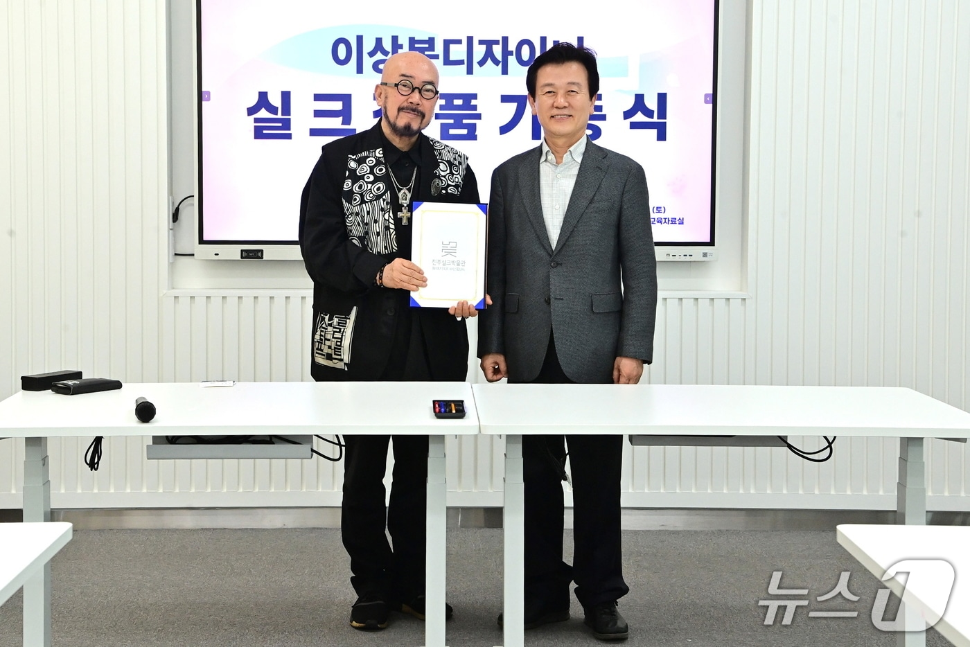 조규일 진주시장(오른쪽)이 지난 4일 진주실크박물관에서 이상봉 패션 디자이너(왼쪽)의 실크 작품을 기증받고 있다(진주시 제공. 재판매 및 DB금지).