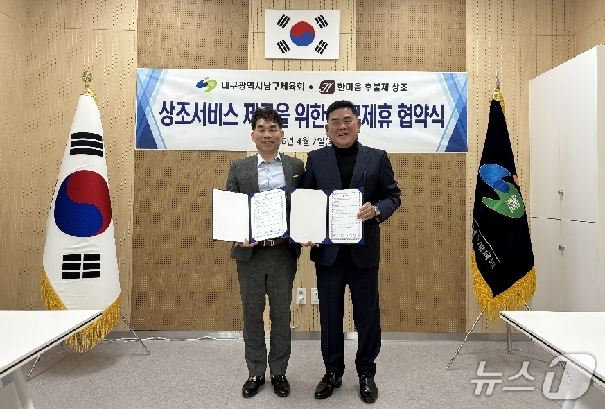 권복만 대구 남구체육회장(왼쪽)과 김수열 한마음 후불제 상조회 대표가 건전한 장례문화 정착을 위한 업무협약을 체결한 뒤 협약서를 펼쳐 보이고 있다.(대구 남구체육회 제공, 재판매 및 DB 금지)