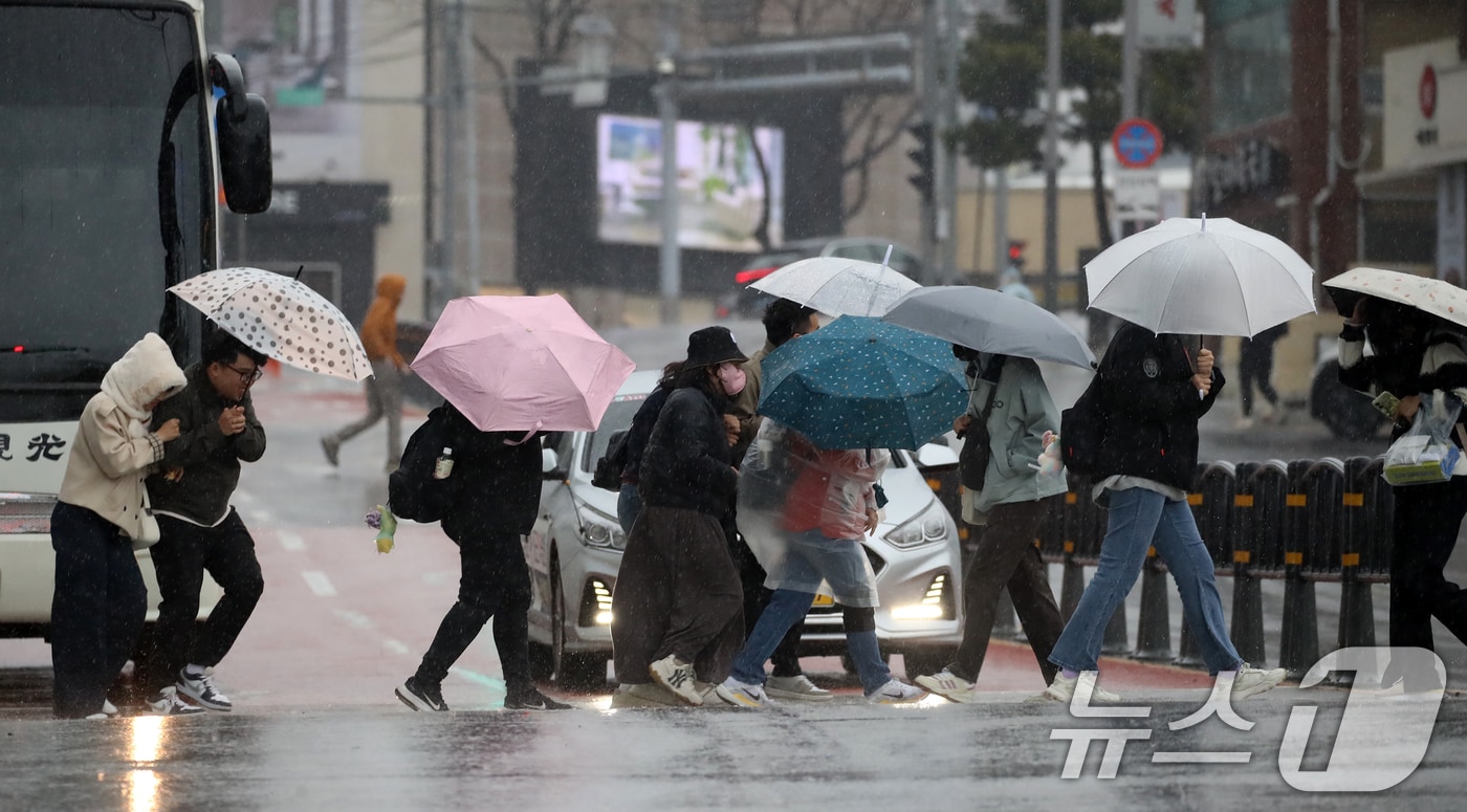 전국적으로 비가 내리는 9일 오후 부산 해운대해수욕장 인근에서 외국인 관광객 등이 강풍에 우산을 부여잡고 힘겹게 발걸음을 옮기고 있다. 2026.4.9 ⓒ 뉴스1 윤일지 기자