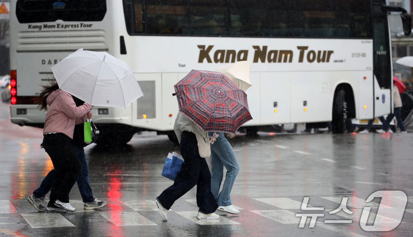 전국적으로 비가 내리는 9일 오후 부산 해운대해수욕장 인근에서 외국인 관광객들이 강풍에 우산을 부여잡고 힘겹게 발걸음을 옮기고 있다. 2026.4.9 ⓒ 뉴스1 윤일지 기자