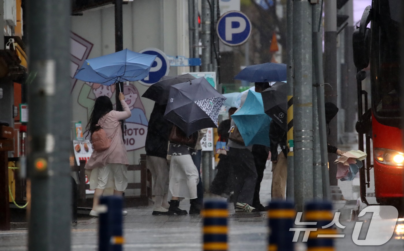 전국적으로 비가 내리는 9일 오후 부산 해운대해수욕장 인근에서 외국인 관광객들이 강풍에 우산을 부여잡고 힘겹게 발걸음을 옮기고 있다. 2026.4.9 ⓒ 뉴스1 윤일지 기자