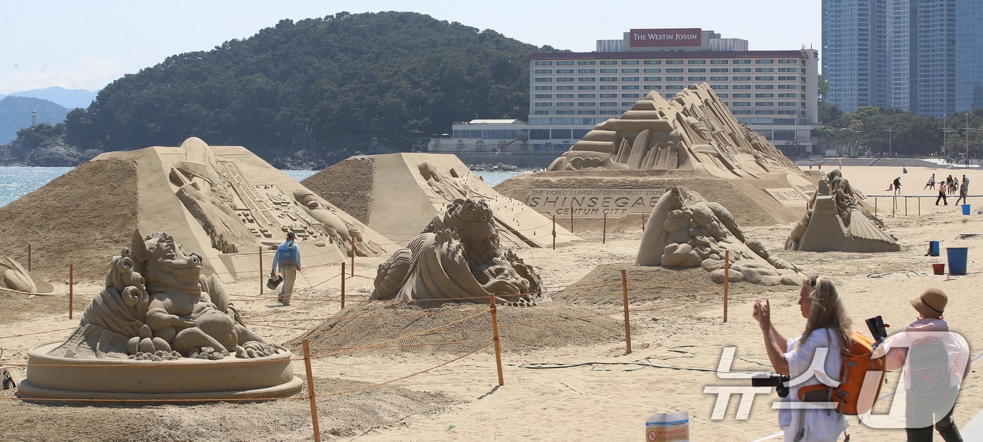 11일 오후 부산 해운대해수욕장을 찾은 외국인 관광객들이 제작 중인 다양한 모래조각 작품을 구경하고 있다. 15~18일 이곳에서 열리는 '2026 해운대 모래축제'에서는 부산의 역사와 문화, 주요 랜드마크를 담은 모래 작품 17점이 전시될 예정이다. 2026.5.11 ⓒ 뉴스1 윤일지 기자
