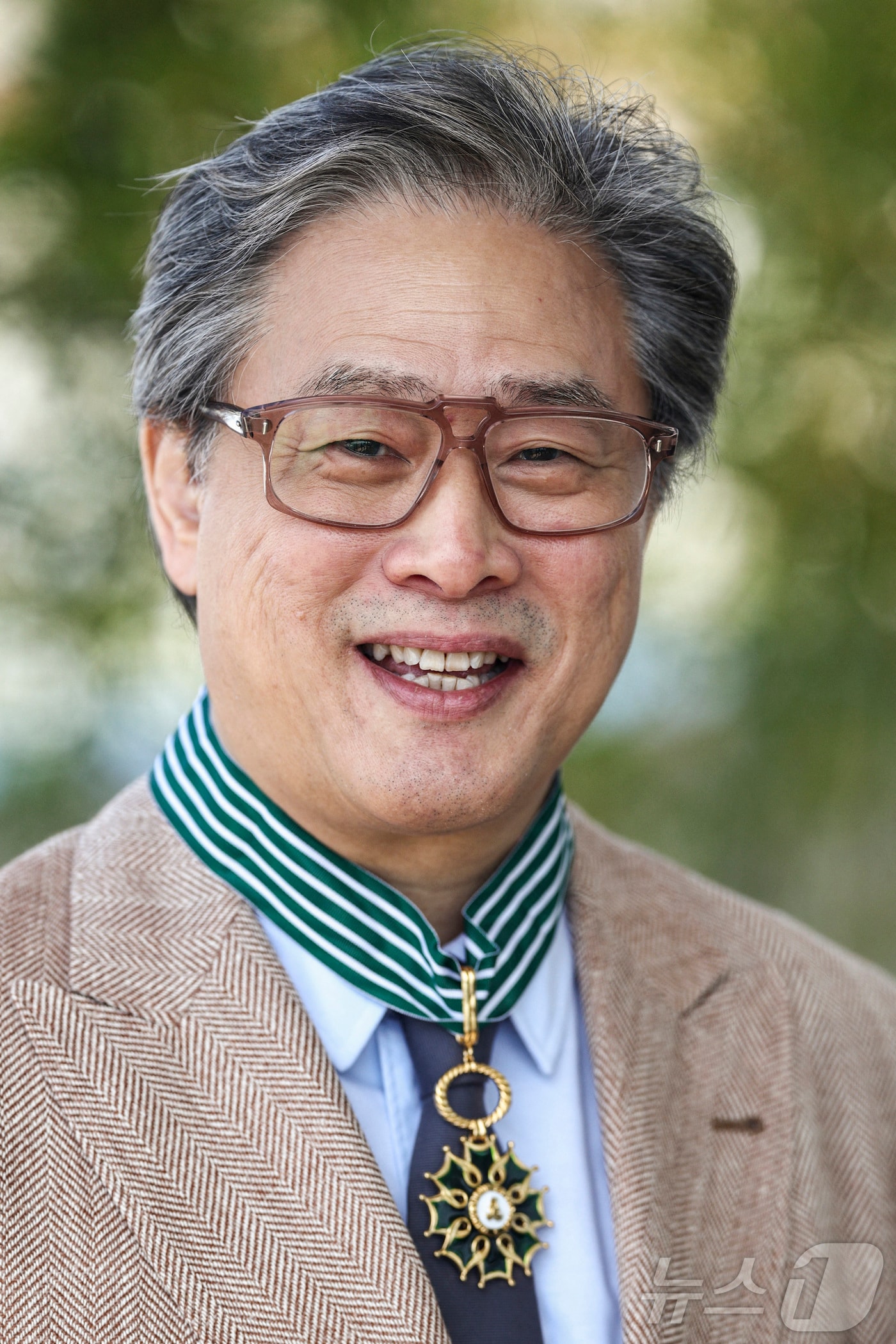 제79회 칸 국제영화제 경쟁부문 심사위원장인 박찬욱 감독이 17일(현지시간) 프랑스 남부 칸에서 프랑스 문화예술공로훈장 최고 등급인 ‘코망되르’를 받은 뒤 훈장을 목에 걸고 있다. 2026.5.17 ⓒ 뉴스1 ⓒ 로이터=뉴스1