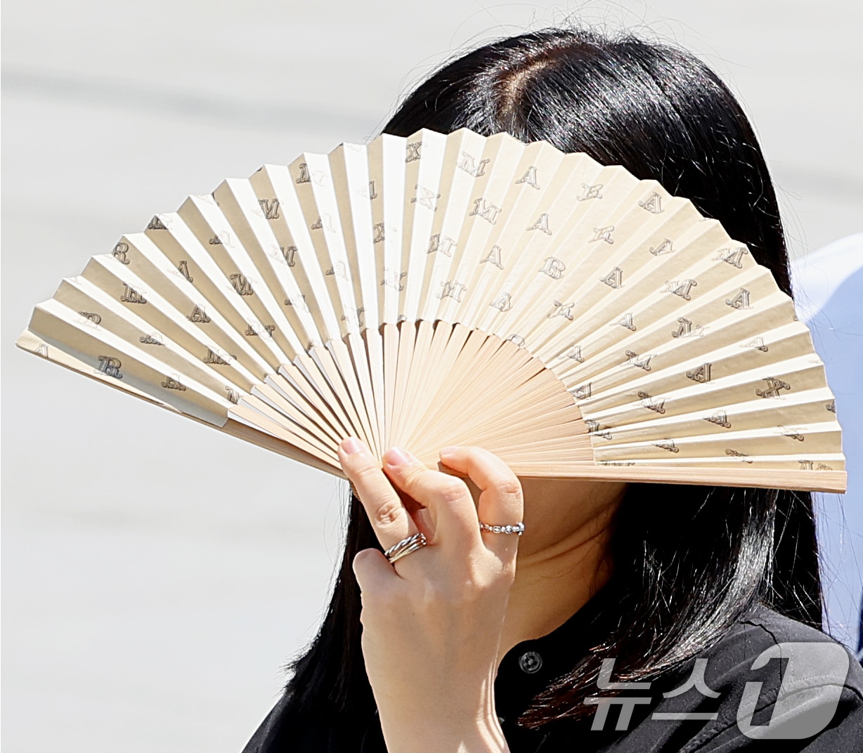 맑은 날씨 속 낮 최고기온이 30도 안팎까지 오른 18일 오후 서울 광화문광장에서 시민이 부채로 햇살을 가리며 발걸음을 옮기고 있다. 2026.5.18 ⓒ 뉴스1 조연우 인턴기자