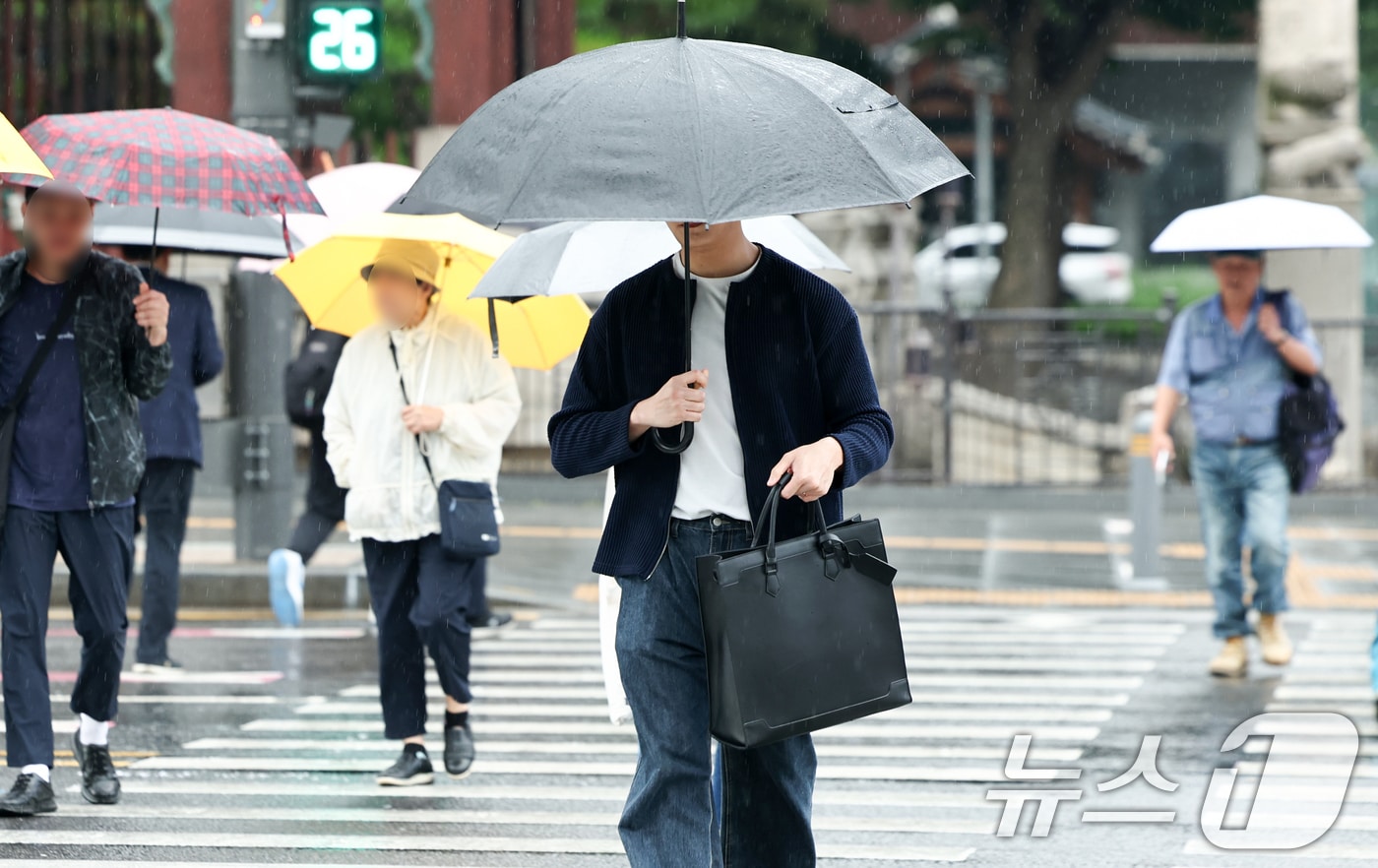 전국 대부분 지역에 비가 내리는 20일 오전 서울 종로구 광화문광장에서 우산을 쓴 시민들이 이동하고 있다. 2026.5.20 ⓒ 뉴스1 최지환 기자