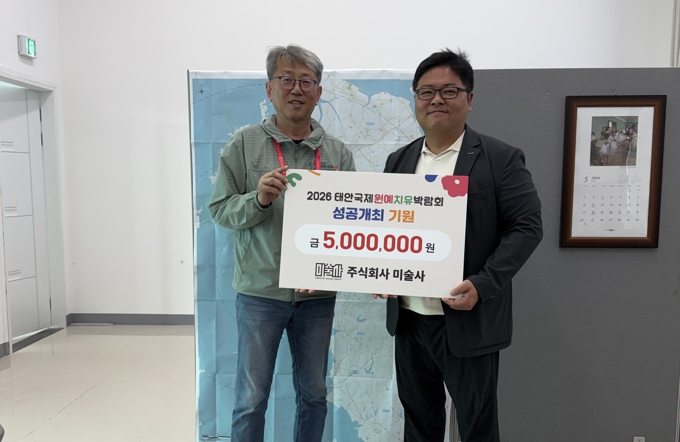 오진기 태안박람회 조직위 사무총장(왼쪽)이 이준석 미술사 대표로부터 500만 원을 기탁받고 기념찰영을 하고 있다.(조직위 제공. 재판매 및 DB금지)/뉴스1