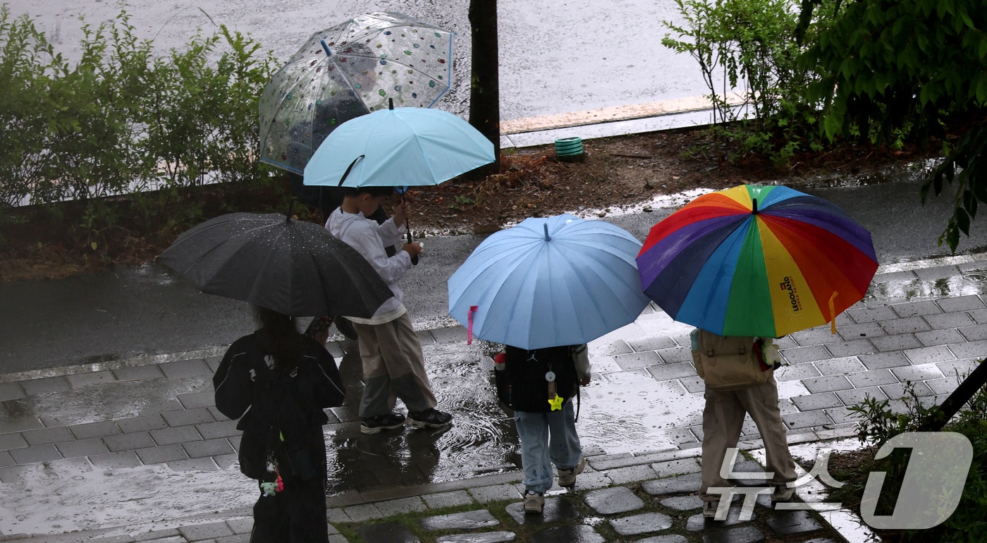 비가 내린 20일 전북 완주군 삼봉로에서 우산을 쓴 어린이들이 발걸음을 옮기고 있다. ⓒ 뉴스1 유경석 기자
