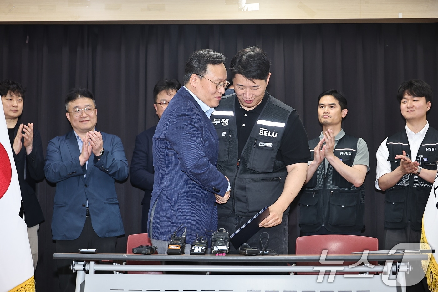 20일 경기도 수원시 장안구 경기고용노동청에서 열린 삼성전자 임금협상을 마친 후 여명구 삼성전자 DS(디바이스솔루션·반도체 사업 담당) 피플팀장과 최승호 삼성그룹 초기업노동조합 삼성전자지부 위원장이 잠정 합의한에 서명한 후 손을 맞잡고 있다. (공동취재) 2026.5.20 ⓒ 뉴스1 김영운 기자
