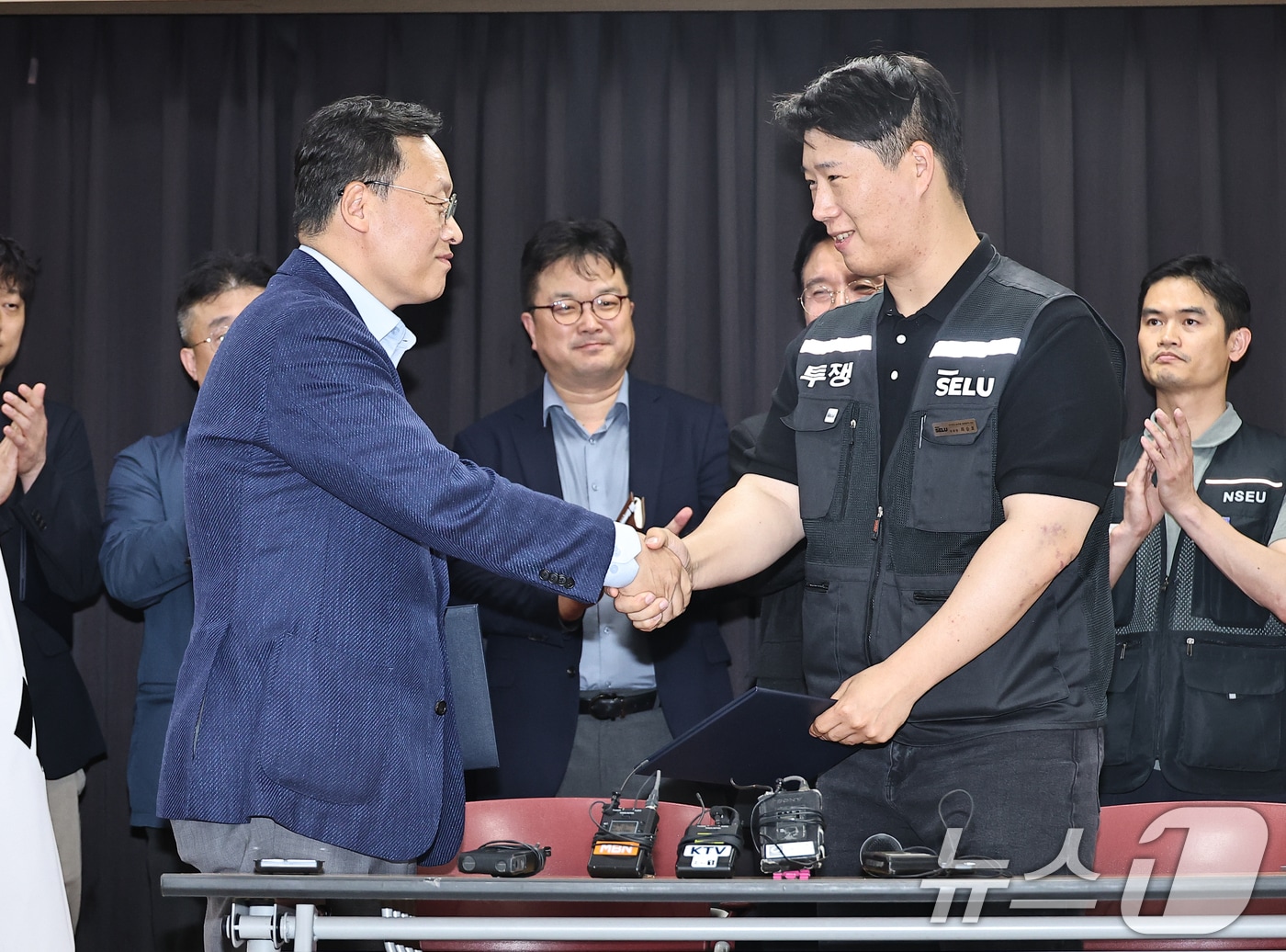 20일 경기 수원시 장안구 경기고용노동청에서 열린 삼성전자 임금협상을 마친 후 여명구 삼성전자 DS(디바이스솔루션·반도체 사업 담당) 피플팀장과 최승호 삼성그룹 초기업노동조합 삼성전자지부 위원장이 악수를 하고 있다. (공동취재) 2026.5.20 ⓒ 뉴스1 김영운 기자