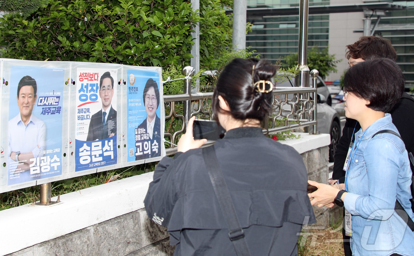 시민들이 22일 오전 제주시 이도2동 통계교육원 제주수련원 정문 울타리에 붙여진 제9회 전국동시지방선거 제주도지사·제주도교육감 선거 후보자 선거벽보를 살펴보고 있다. 2026.5.22 ⓒ 뉴스1 오미란 기자