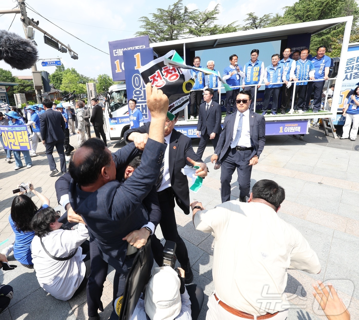 정청래 더불어민주당 총괄상임선대위원장이 25일 전북 전주시 전북대학교 구정문 앞에서 열린 집중유세에 참석해 민주당 후보 지지를 호소하던 중 한 남성이 "정청래 아웃"이라고 외치며 뛰어들자 경호원들이 제지하고 있다. 2026.5.25 ⓒ 뉴스1 유경석 기자