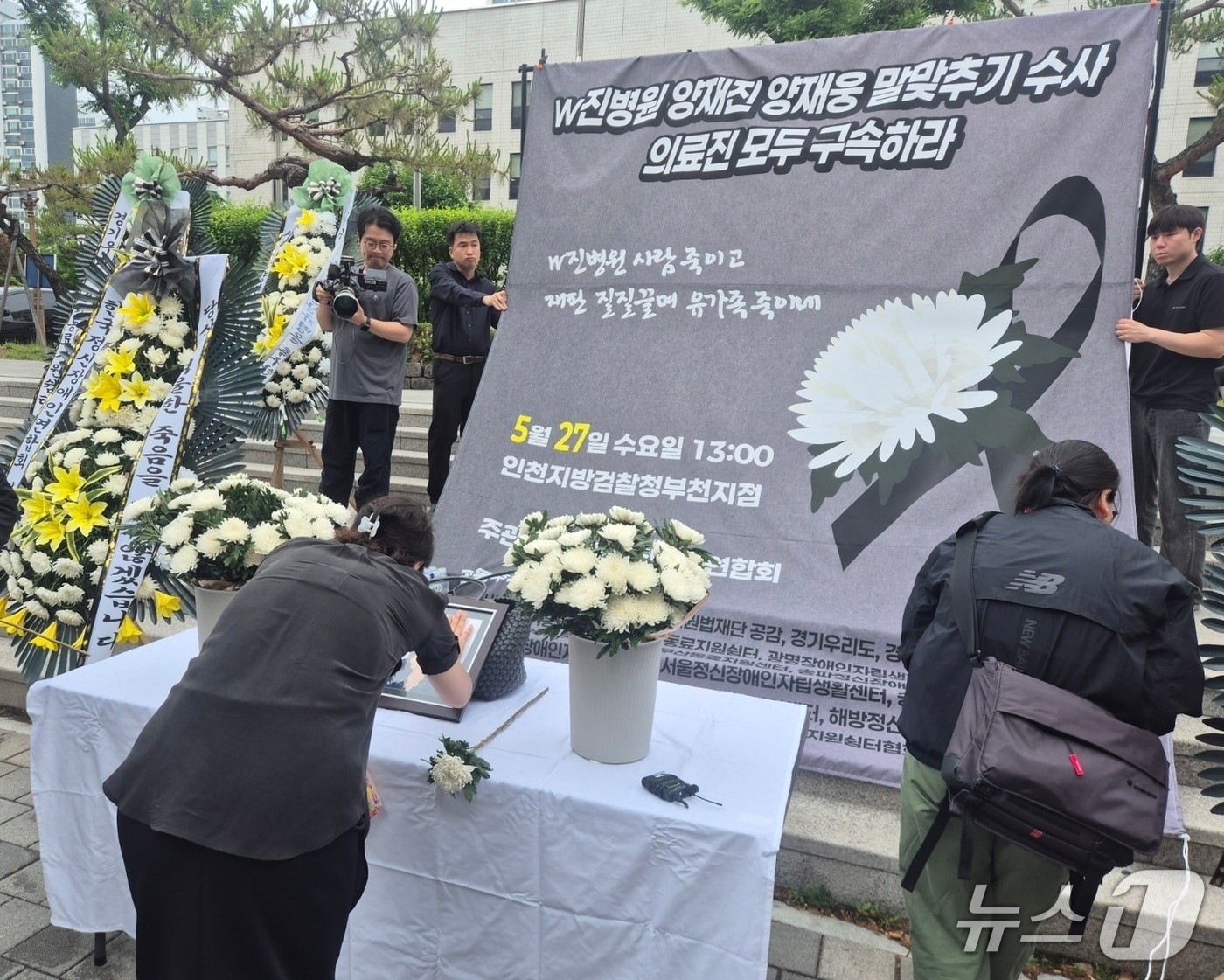 27일 한국정신장애인연합회가 개최한 '격리·강박 사망 사건 2주기 추모제'에 참여한 유족이 헌화를 하고 있다./뉴스1