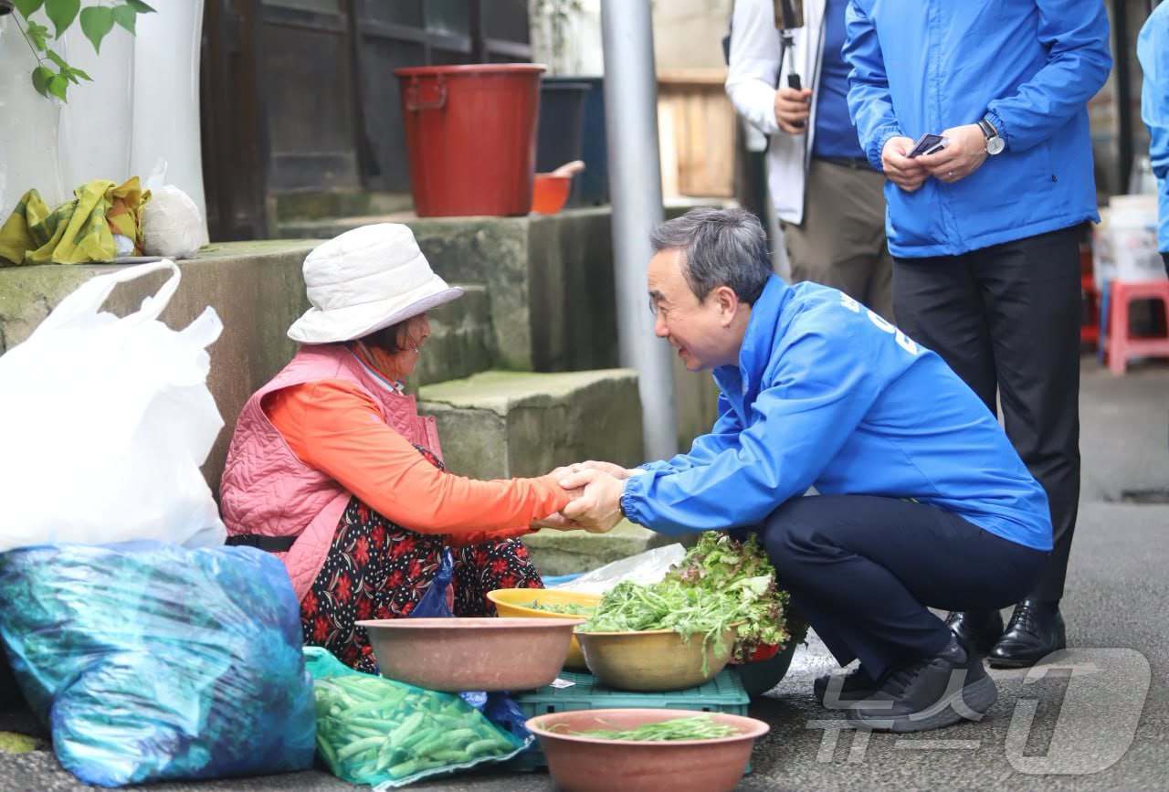 임문영 더불어민주당 광주 광산을 재보선 후보가 유세 도중 전통시장에서 채소를 파는 노점상과 악수하고 있다.(임문영 캠프 제공. 재배포 및 DB 금지)