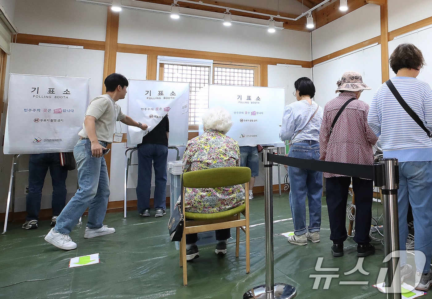 제9회 전국동시지방선거 사전투표 둘째 날인 30일 대구 중구 복합문화공간 하누리어울림센터에 마련된 남산2동 사전투표소에서 투표사무원이 기표소 내부가 보이지 않도록 커튼으로 가려주고 있다. 2026.5.30 ⓒ 뉴스1 공정식 기자