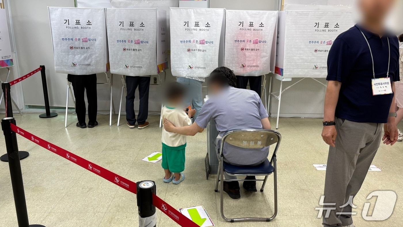 6.3지방선거 사전투표 둘째 날인 30일 경남 창원시 봉림동 사전투표소에서 투표장 관계자가 기표소에 들어간 부모를 기다리는 아이를 잠시 돌봐주고 있다.2026.5.30/뉴스1 강정태 기자