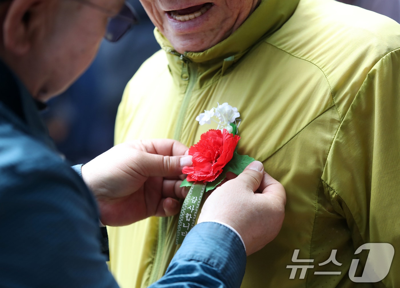 어버이날을 하루 앞둔 7일 대구 달서구 두류공원 '사랑해밥차' 무료급식소에서 봉사자들이 어르신에게 카네이션을 달아주고 있다. 2026.5.7 ⓒ 뉴스1 공정식 기자