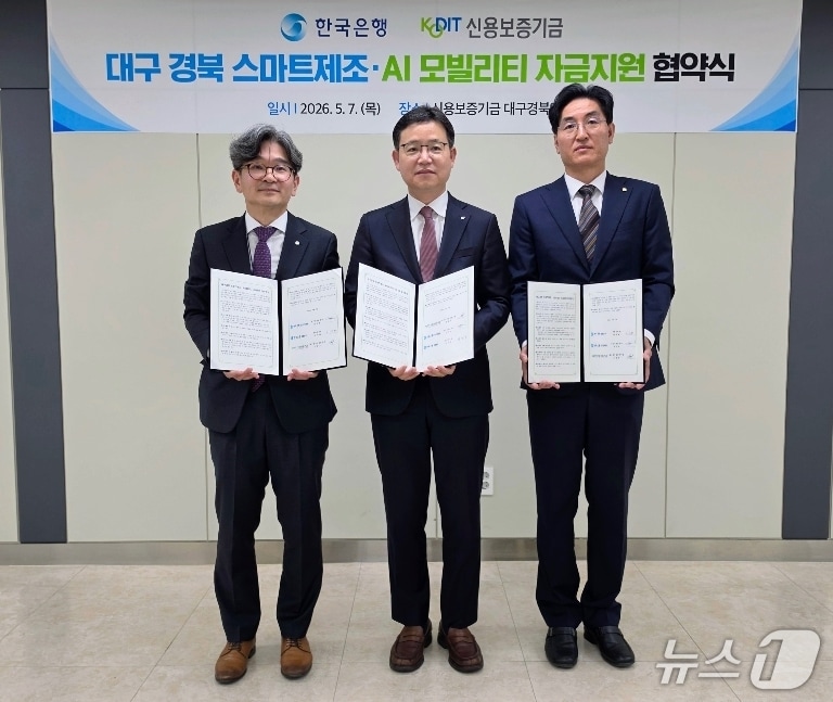 김주현 한국은행 대구경북본부장(왼쪽)과 손용호 신용보증기금 대구경북영업본부장(가운데), 이덕배 한국은행 포항본부장이 스마트 제조·AI 모빌리티 자금 지원을 위한 업무협약을 체결한 뒤 협약서를 펼쳐 보이고 있다.(한은 대구경북본부 제공, 재판매 및 DB 금지)