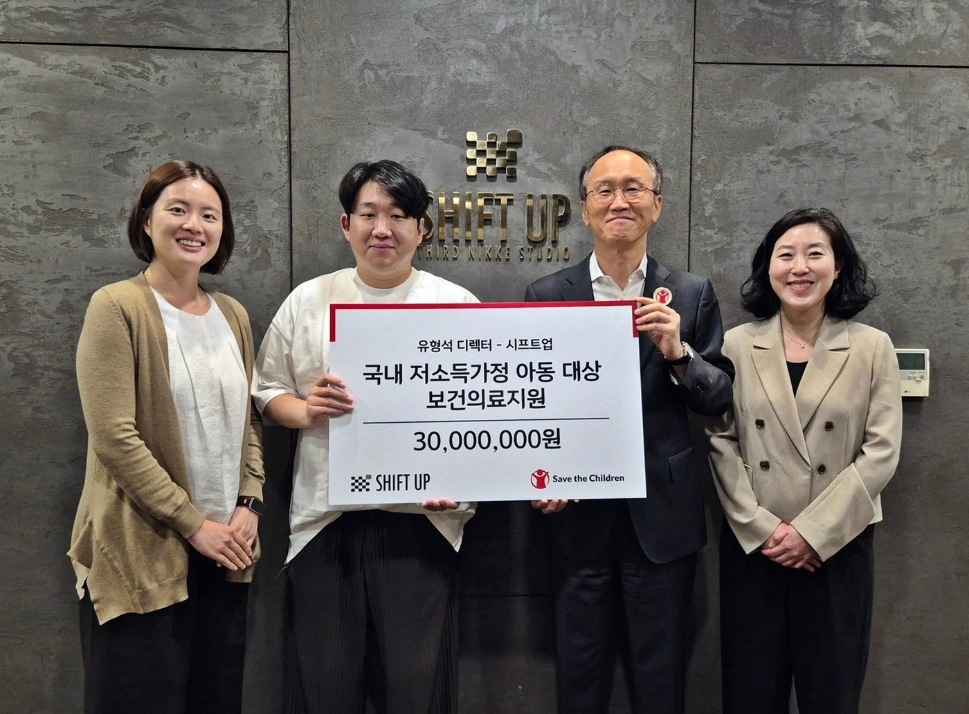유형석 ‘승리의 여신:니케’ 디렉터(왼쪽 두 번째)와 시프트업이 세이브더칠드런에 후원금 3000만 원을 전달했다.(시프트업 제공. 재판매 및 DB금지)2026.5.8 ⓒ 뉴스1