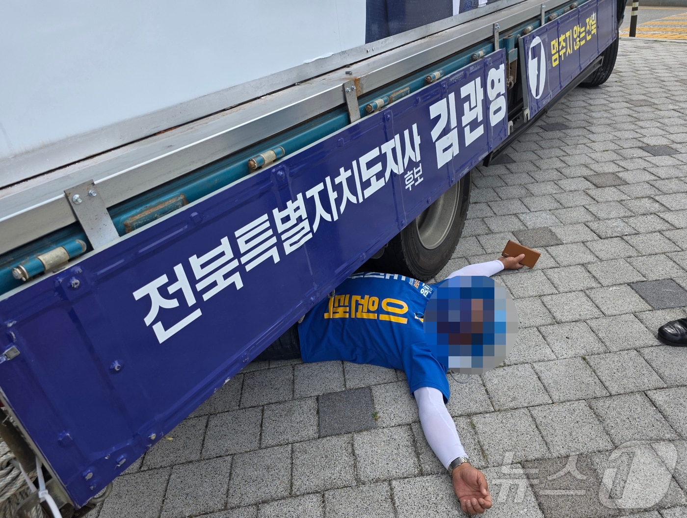 1일 오전 8시 30분께 전북 전주시 효자동의 한 사거리에서 무소속 김관영 전북지사 후보 유세차 밑에 이원택 후보 선거운동원이 드러누운 모습.(독자 제공. 재판매 및 DB 금지) 2026.6.1