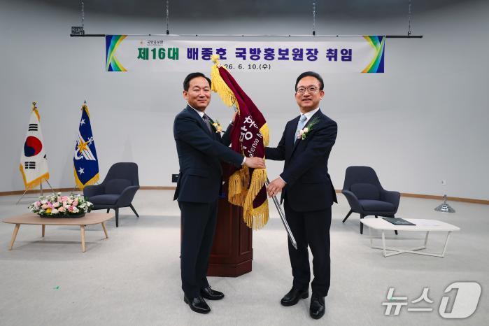 10일 서울 용산구 국방홍보원에서 열린 16대 국방홍보원장 취임식에서 이두희 국방부 차관이 배종호 신임 원장에게 국방홍보원기를 수여하고 있다. (국방일보 제공)