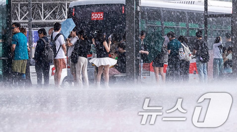 돌풍과 벼락을 동반한 소나기가 내린 14일 서울 종로구 광화문광장 버스정류장에서 시민들이 비를 피하고 있다. 2026.6.14 ⓒ 뉴스1 이호윤 기자