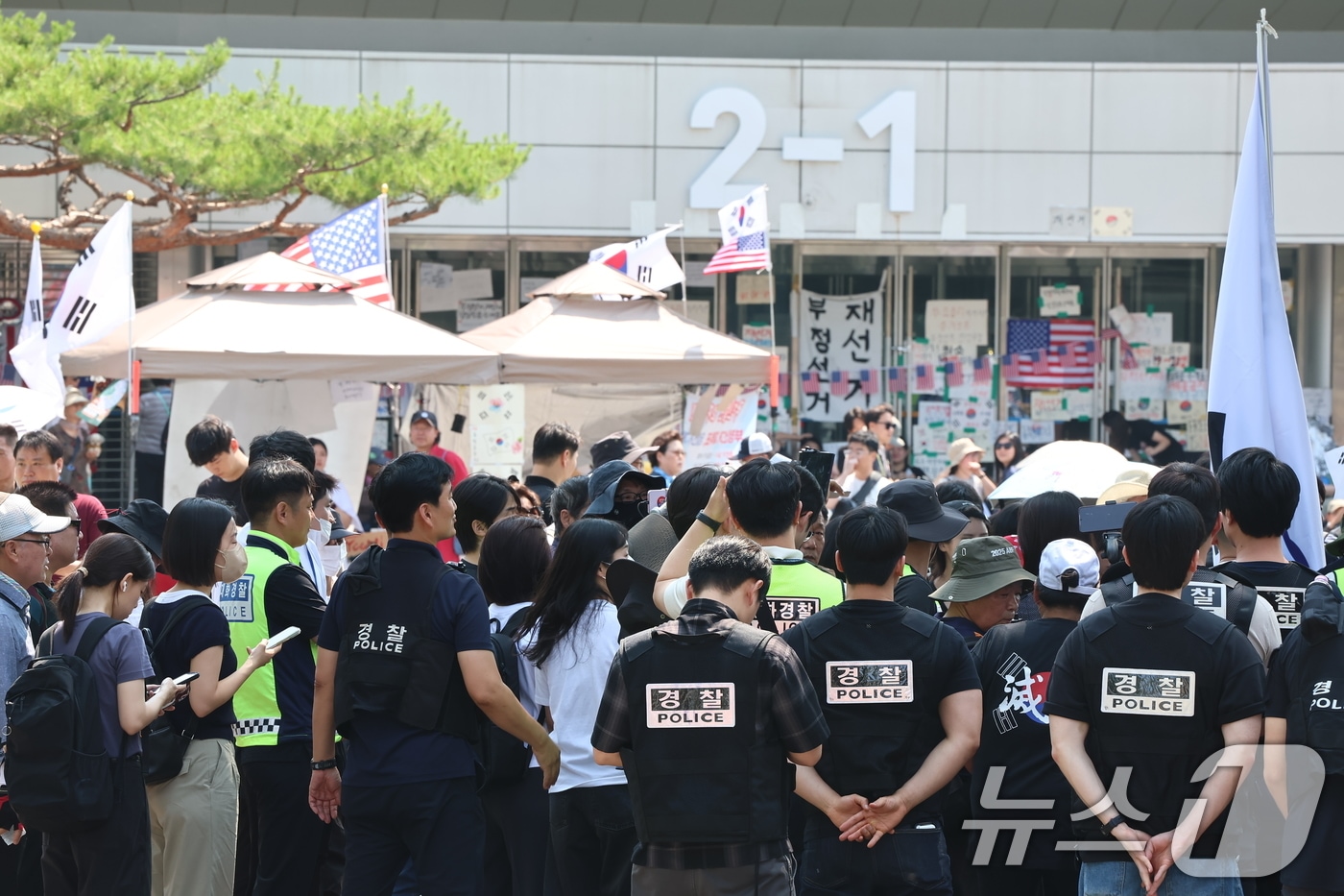 6·3 지방선거 '투표용지 부족 사태'로 12일째 잠실 개표소 봉쇄 시위가 이어지고 있는 16일 경찰과 대한체육회 등관계자들이 서울 송파구 올림픽공원 핸드볼경기장 진입을 시도하다 시위대와 대치하고 있다. 2026.6.16 ⓒ 뉴스1 김도우 기자
