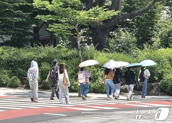 16일 오후 1시 30분께 전북대학교 학생들이 양산을 쓰고 교정을 걷고 있다.2026.6.16/뉴스1 문채연 기자