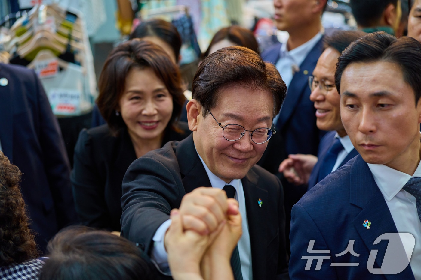 이재명 대통령과 김혜경 여사가 25일 경기 수원시 팔달문시장을 찾아 상인들과 인사하고 있다. (청와대 제공. 재판매 및 DB 금지) 2026.6.25 ⓒ 뉴스1 허경 기자
