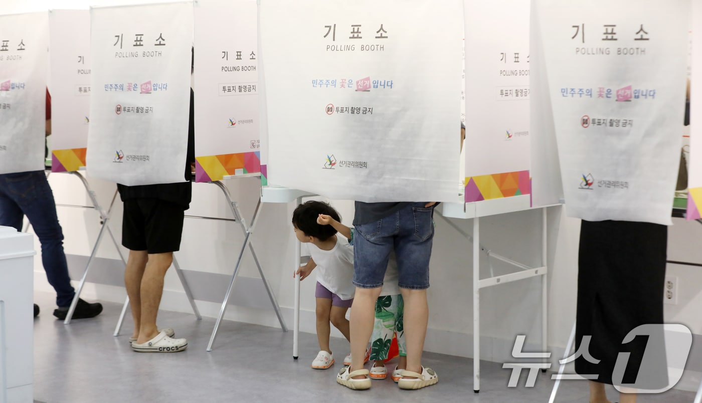 제9회 전국동시지방선거 및 국회의원 재·보궐선거일인 3일 부산 부산진구청에 마련된 부암제1동제4투표소에서 엄마와 투표소를 찾은 아이들이 신기한 듯 바라보고 있다. 2026.6.3 ⓒ 뉴스1 윤일지 기자