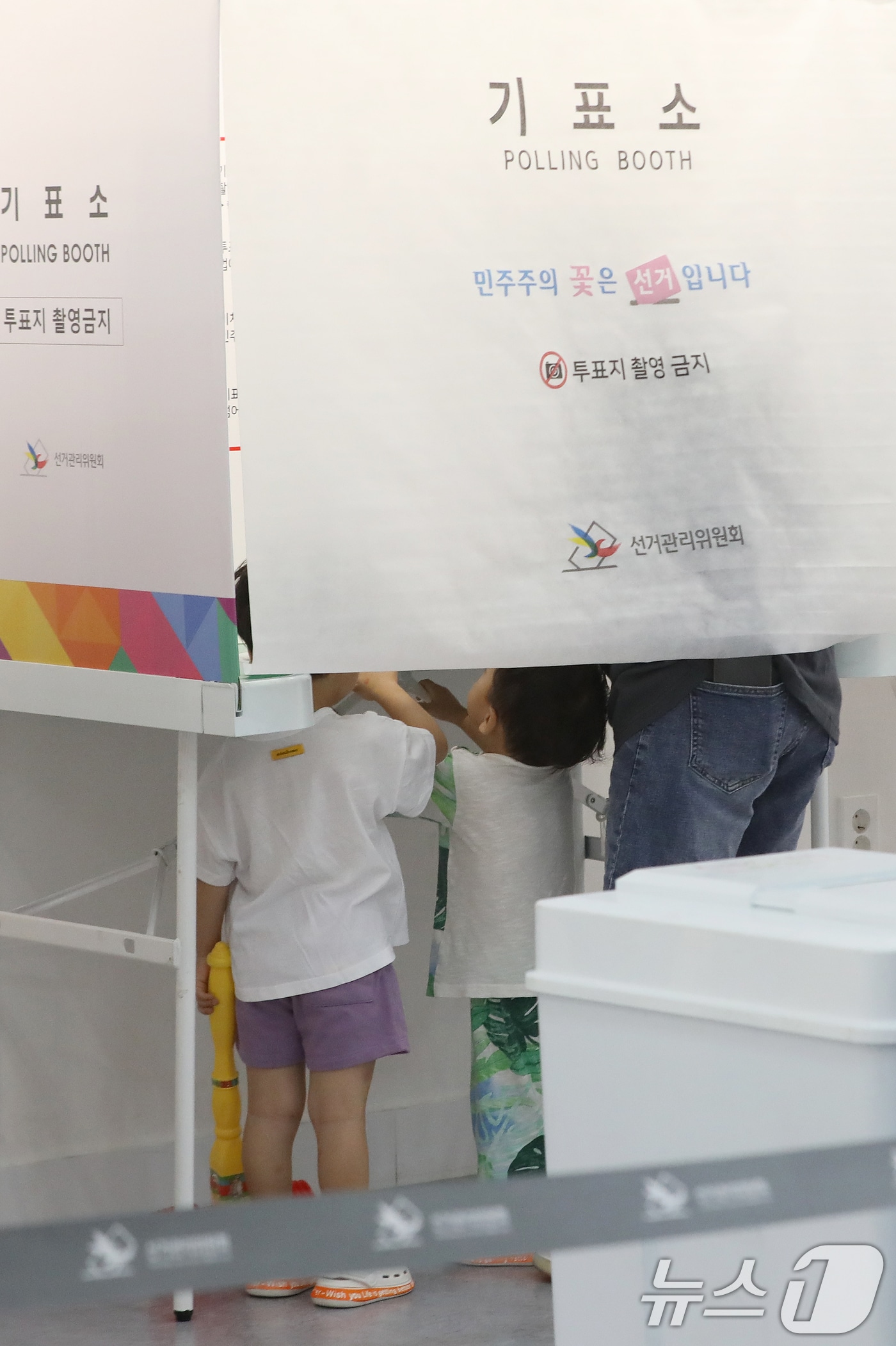 제9회 전국동시지방선거 및 국회의원 재·보궐선거일인 3일 부산 부산진구청에 마련된 부암제1동제4투표소에서 아이들이 엄마가 투표하는 모습을 지켜보고 있다. 2026.6.3 ⓒ 뉴스1 윤일지 기자