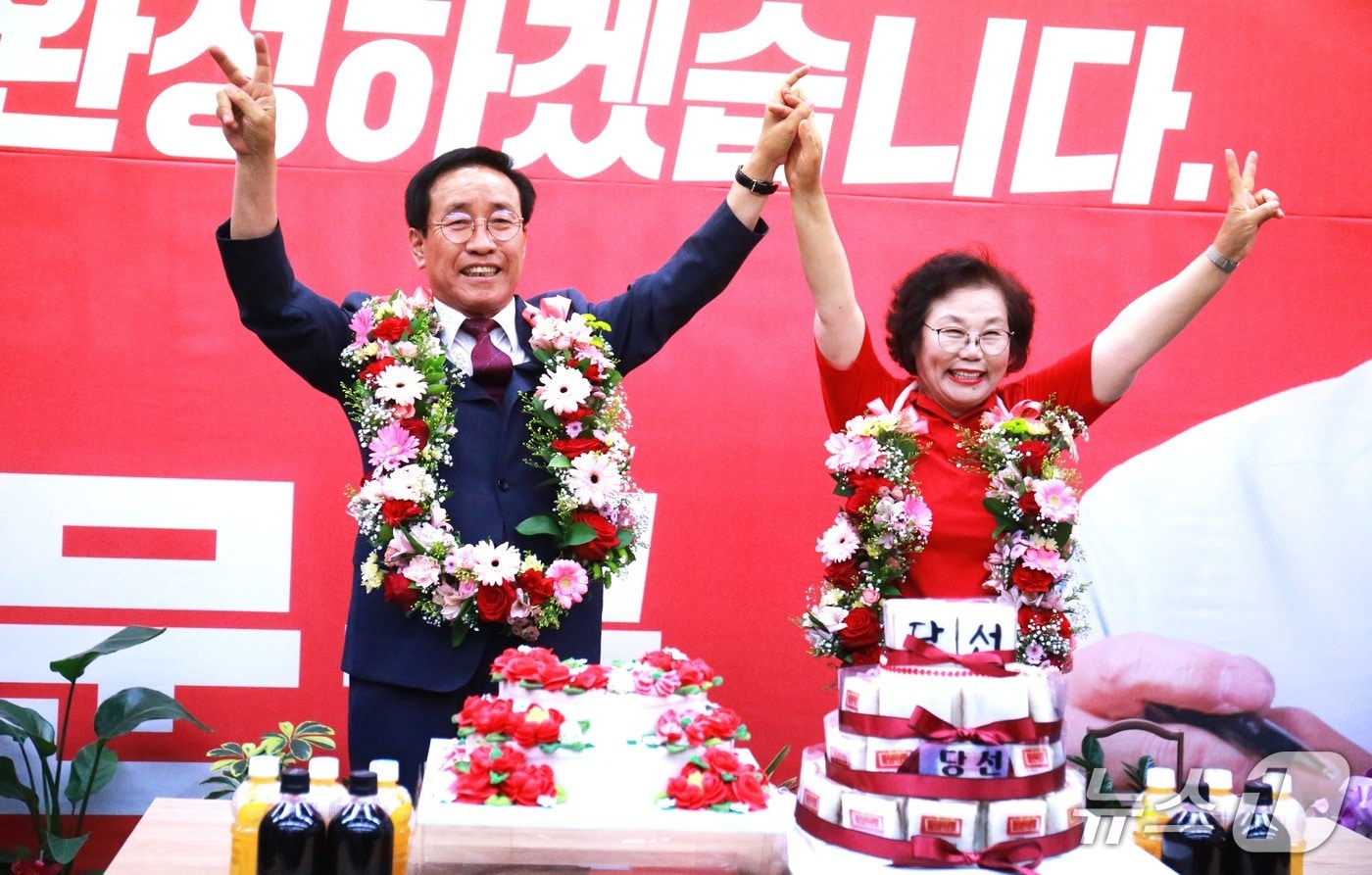 국민의힘 김문근 단양군수 후보가 당선이 확실시 되자, 부인 송이화 여사와 함께 두손을 번쩍 들어 기쁨을 만끽했다.2026.6.3/뉴스1