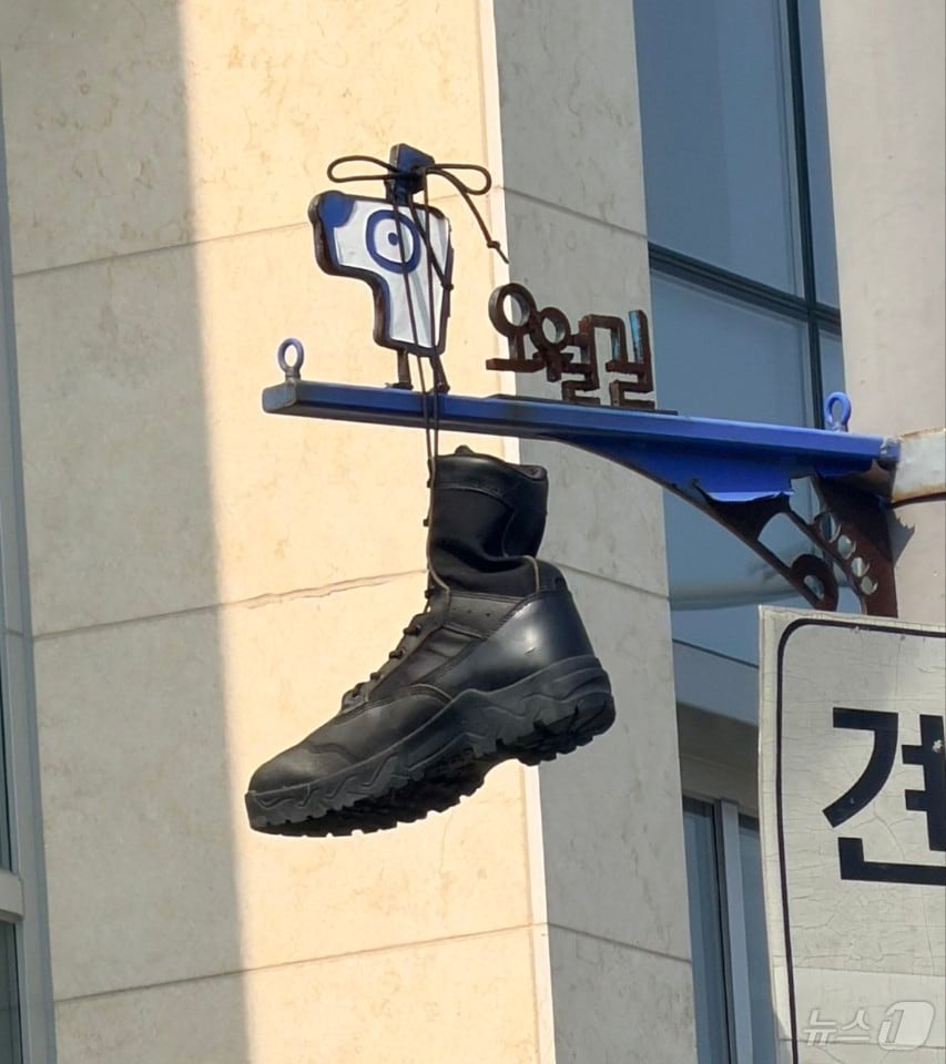 30일 광주 동구 대인동의 한 교차로에 설치된 오월길을 안내하는 표지판에 군화가 걸려 있다. 5.18기념재단과 광주시는 군화를 수거하는 한편 누가, 어떤 의도로 군화를 걸었는지 조사에 착수했다. (5·18기념재단 제공. 재판매 및 DB금지) 2026.6.30 ⓒ 뉴스1 전원 기자