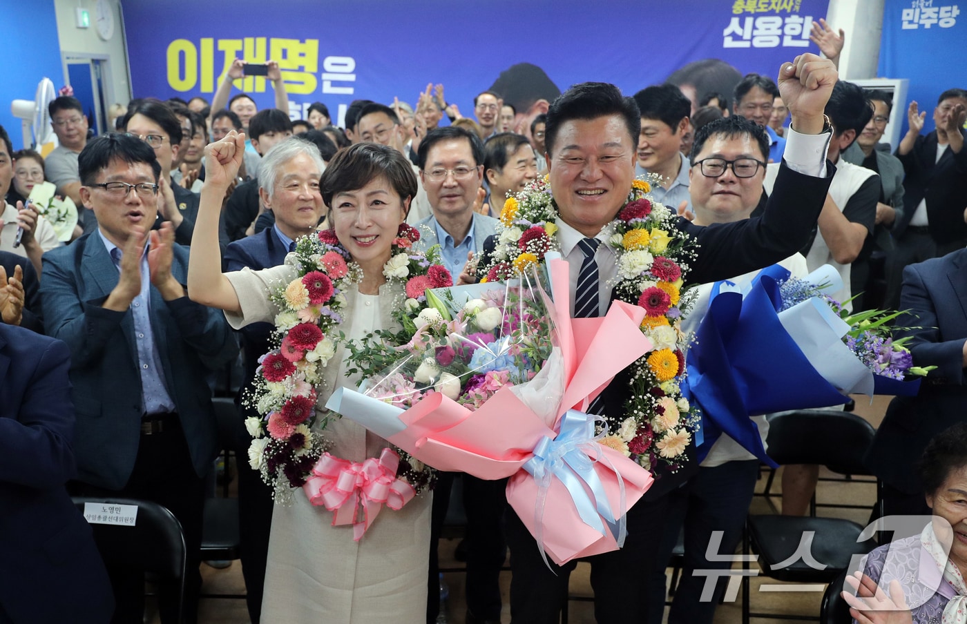 더불어민주당 신용한 충북지사 후보와 배우자 이채영 씨가 3일 오후 충북 청주시 흥덕구 선거사무소에서 당선이 유력시되자 꽃목걸이를 걸고 세리머니를 하고 있다. 2026.6.3 ⓒ 뉴스1 김용빈 기자