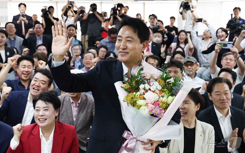 오세훈 국민의힘 서울시장 후보가 4일 서울 종로구에 마련된 본인의 선거사무소에서 당선이 유력해지자 입장 발표 후 꽃다발을 안은 채 환호히고 있다. 2026.6.4 ⓒ 뉴스1 김도우 기자