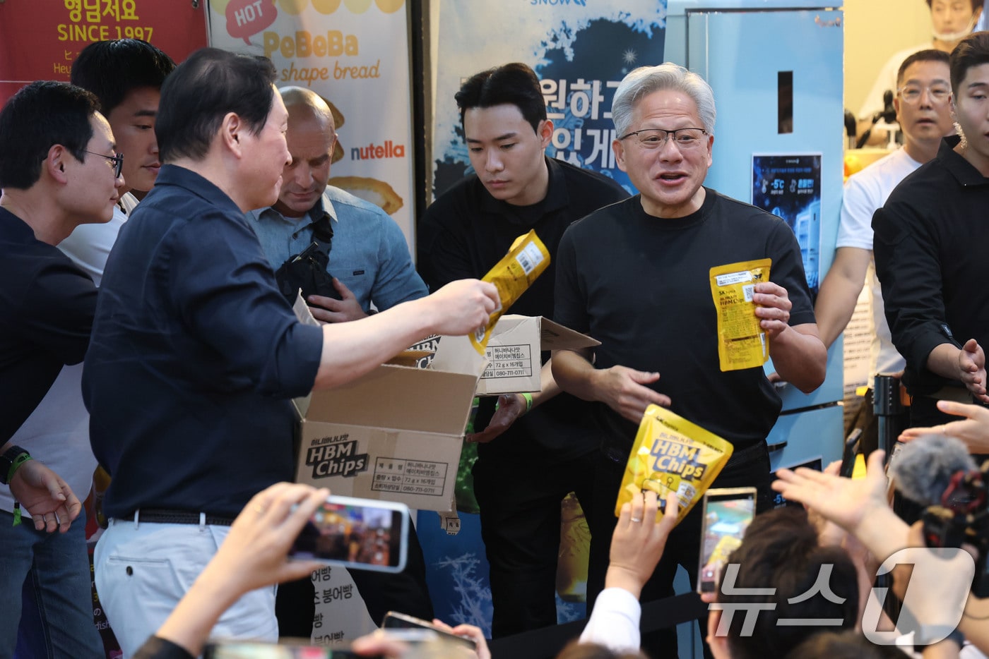 젠슨 황 엔비디아 최고경영자(CEO)가 5일 서울 마포구 홍익대학교 인근 고깃집에서 최태원 SK회장, 구광모 LG회장, 이해진 네이버 의장과 삼겹살·소맥(소주·맥주) 회동 중 잠시 나와 HBM칩스를 나눠주고 있다. 2026.6.5 ⓒ 뉴스1 이광호 기자