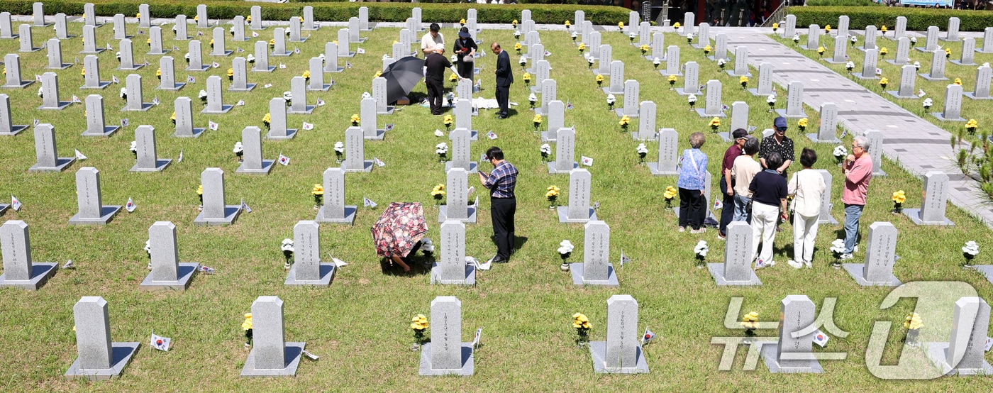 현충일인 6일 전북 전주시 군경묘지를 찾은 추모객들이 참배를 하고 있다. 2026.6.6 ⓒ 뉴스1 유경석 기자