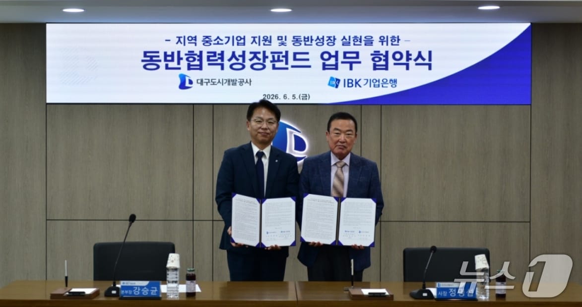 정명섭 대구도시개발공사 사장(오른쪽)과 강승균 IBK기업은행 대구경북동부지역본부장이 중소기업 지원을 위한 동반협력성장펀드 업무협약을 체결한 뒤 협약서를 펼쳐 보이고 있다.(대구도시개발공사 제공, 재판매 및 DB 금지)