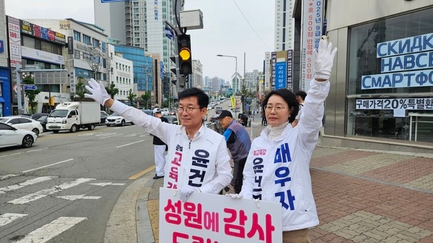 재선에 성공한 윤건영 충북교육감이 8일 오전 부인 하정혜 씨와 함께 청주 사창사거리에서 거리 인사를 하고 있다.(독자 제공. 재판매 및 DB금지) ⓒ 뉴스1