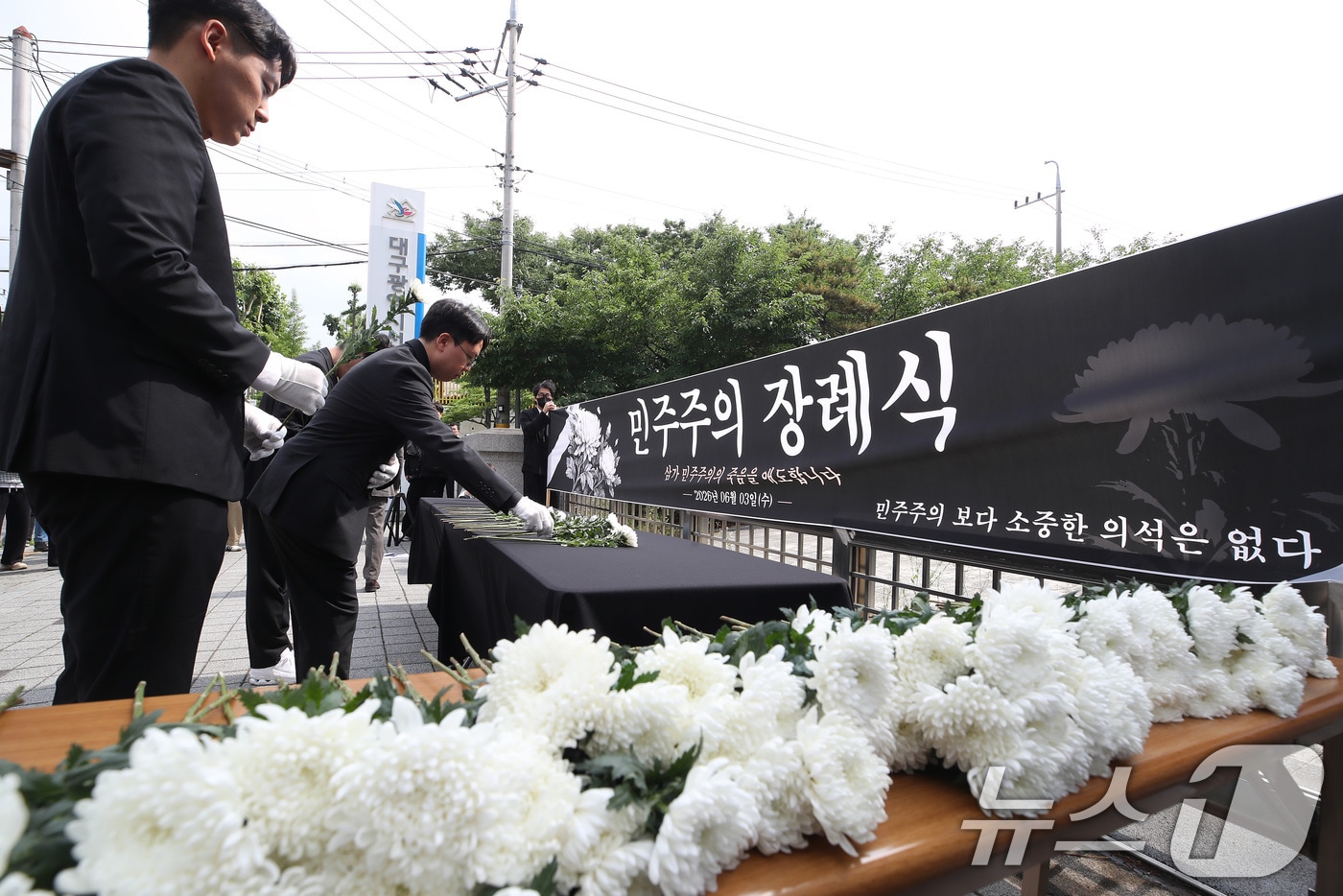 국민의힘 소속으로 6·3 지방선거에 출마해 대구 수성구의원에 당선된 김경민·박새롬 구의원과 시민들이 8일 오후 대구시 선거관리위원회 앞에서 투표용지 부족 사태 등 선거관리 부실에 대한 진상규명과 선관위 책임자 엄중 조사·처벌, 재선거 등을 주장하며 민주주의 장례식을 열고 있다. 2026.6.8 ⓒ 뉴스1 공정식 기자