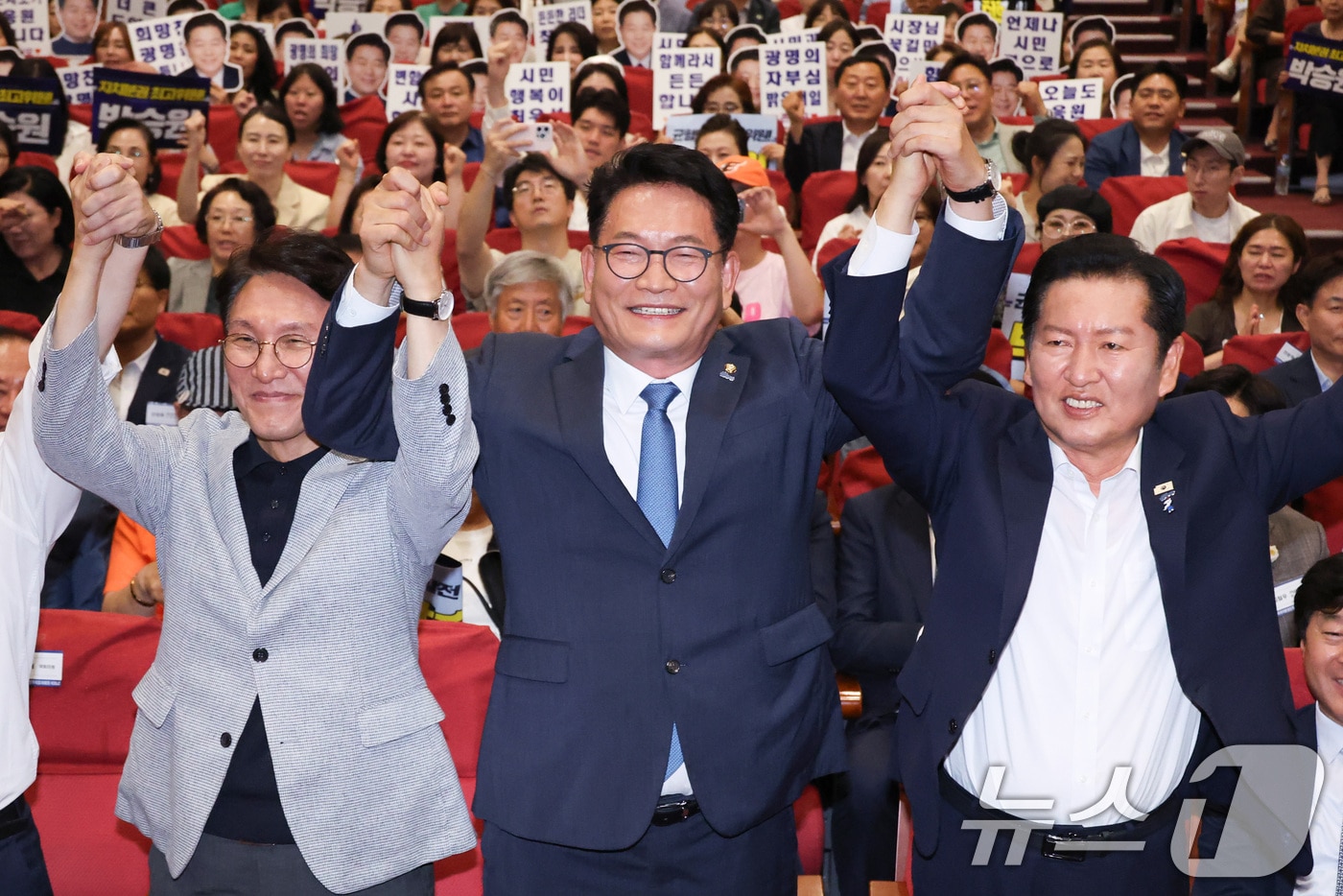 김민석(왼쪽부터)·송영길·정청래 더불어민주당 당대표 후보가 12일 서울 여의도 국회 의원회관에서 열린 전국자치분권민주지도자회의 당대표 후보 정견 발표에서 손을 잡고 기념 촬영하고 있다. 2026.7.12 ⓒ 뉴스1 신웅수 기자
