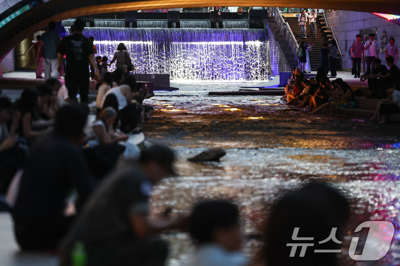 서울 전역에 열대야주의보가 발효된 13일 저녁 서울 청계천을 찾은 관광객과 시민들이 더위를 식히고 있다. 2026.7.13 ⓒ 뉴스1 김도우 기자
