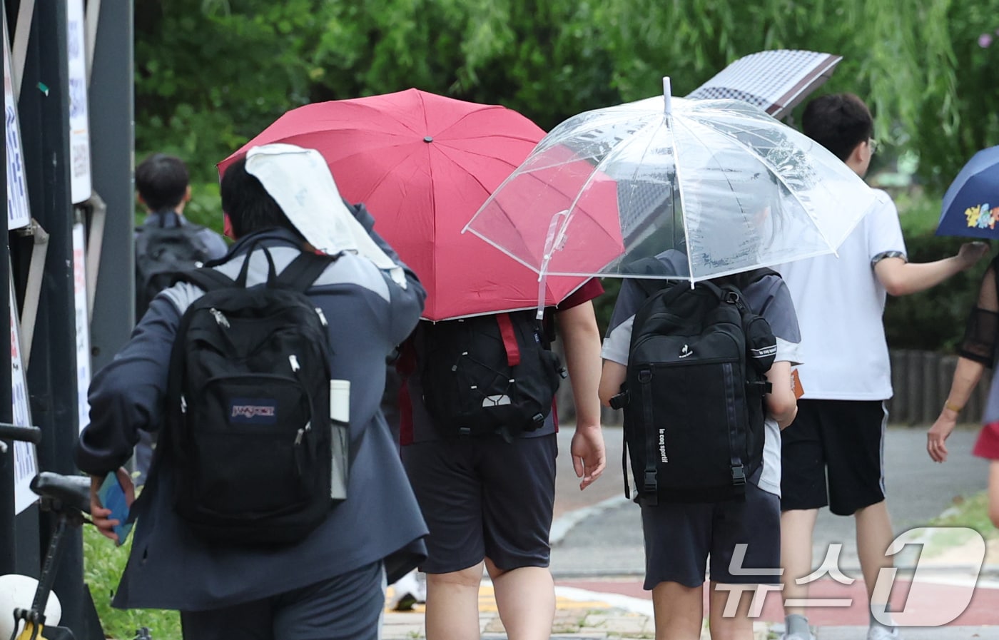 14일 경기 수원시의 한 도로에서 학생들이 우산을 쓰고 하교를 하고 있다. 기상청에 따르면 이날 밤부터 15일 새벽 사이 중부지방과 전라권을 중심으로 돌풍과 천둥·번개를 동반한 강한 비가 내리겠다. 2026.7.14 ⓒ 뉴스1 김영운 기자