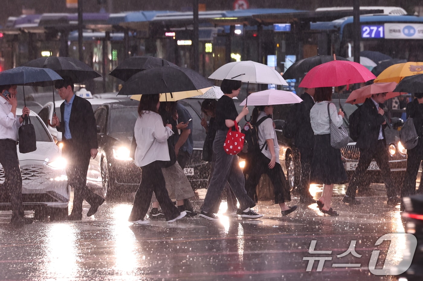수도권 곳곳에 호우주의보가 내려진 14일 오후 서울 종로구 광화문 네거리에서 시민들이 강한 빗줄기 속 퇴근길 발걸음을 재촉하고 있다. 2026.7.14 ⓒ 뉴스1 구윤성 기자