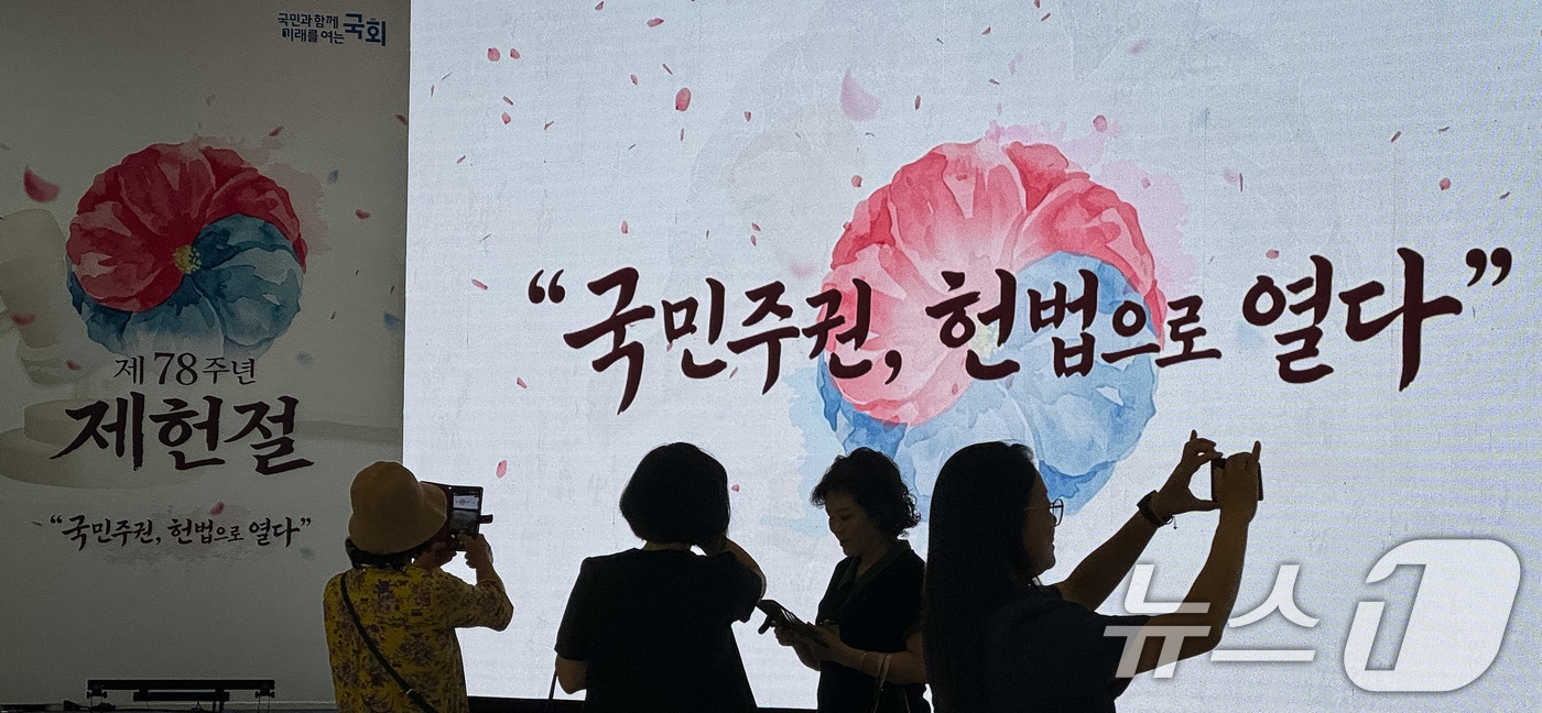 제78주년 제헌절을 하루 앞둔 16일 서울 여의도 국회를 찾은 참관객들이 로텐더홀에 마련중인 경축식 행사장을 배경으로 기념 촬영을 하고 있다. 2026.7.16 ⓒ 뉴스1 유승관 기자