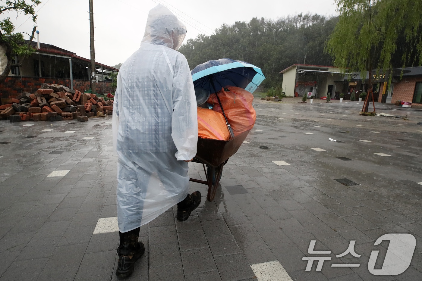 19일 경북 안동시 일직면 귀미리 산불 이재민 주거용 임시 주택 일대가 집중호우로 침수된 가운데 수해 복구 현장에 다시 폭우가 쏟아지자 한 이재민이 가재도구를 꺼내 옮기고 있다. 2026.7.19 ⓒ 뉴스1 공정식 기자